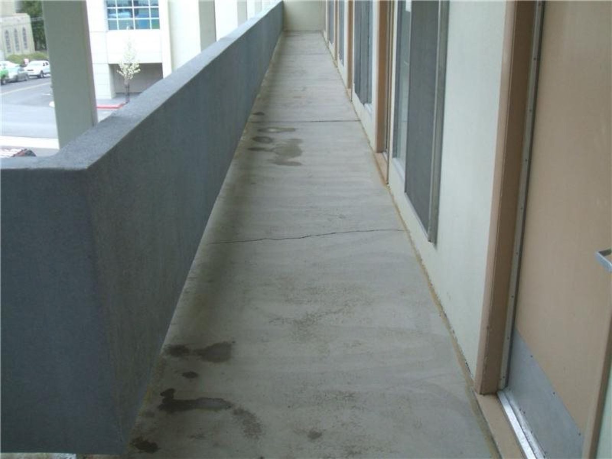 Cracked, stained concrete walkway before resurfacing